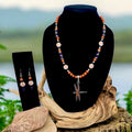 Copper goldstone beaded necklace with flower accents and a dragonfly pendant, displayed with matching drop earrings on a black bust.
