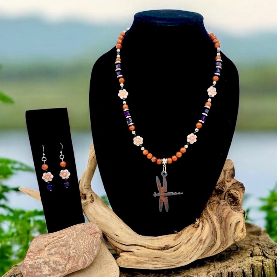 Copper goldstone beaded necklace with flower accents and a dragonfly pendant, displayed with matching drop earrings on a black bust.